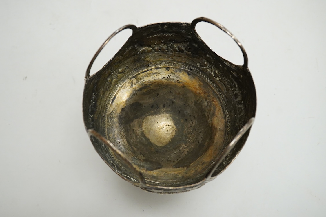 A late 19th/early 20th century Indian white metal pedestal bowl, with unusual ring handle border, embossed with continuous scene of wild animals, diameter 12.3cm, 6.3oz.